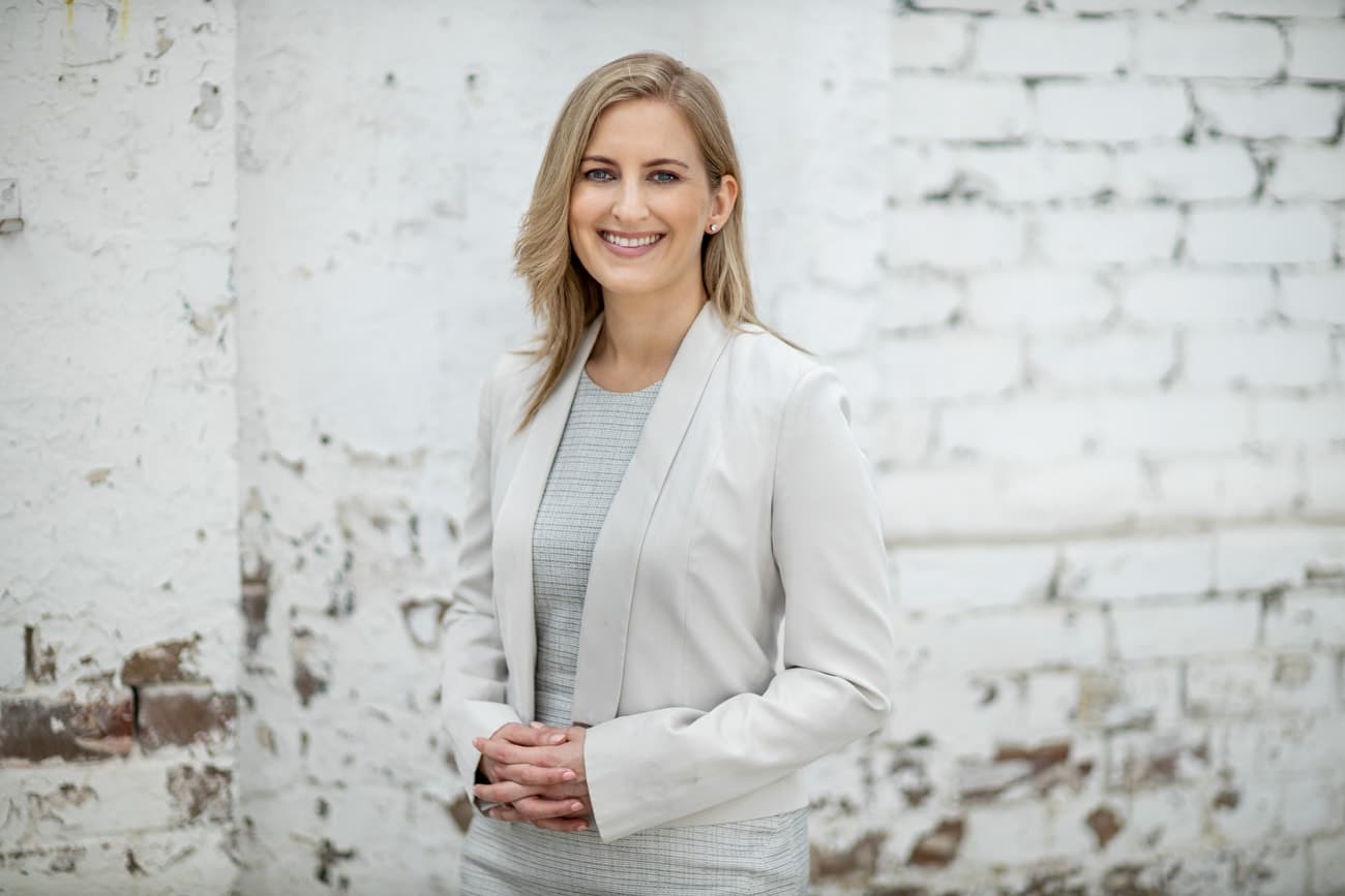 corporate headshot female in studio with white brick wall