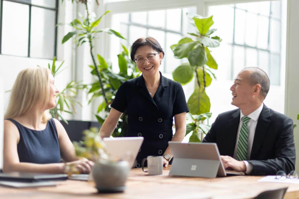 Stock photography - hero shot photography - financial services - lady smiling standing up - greenery background