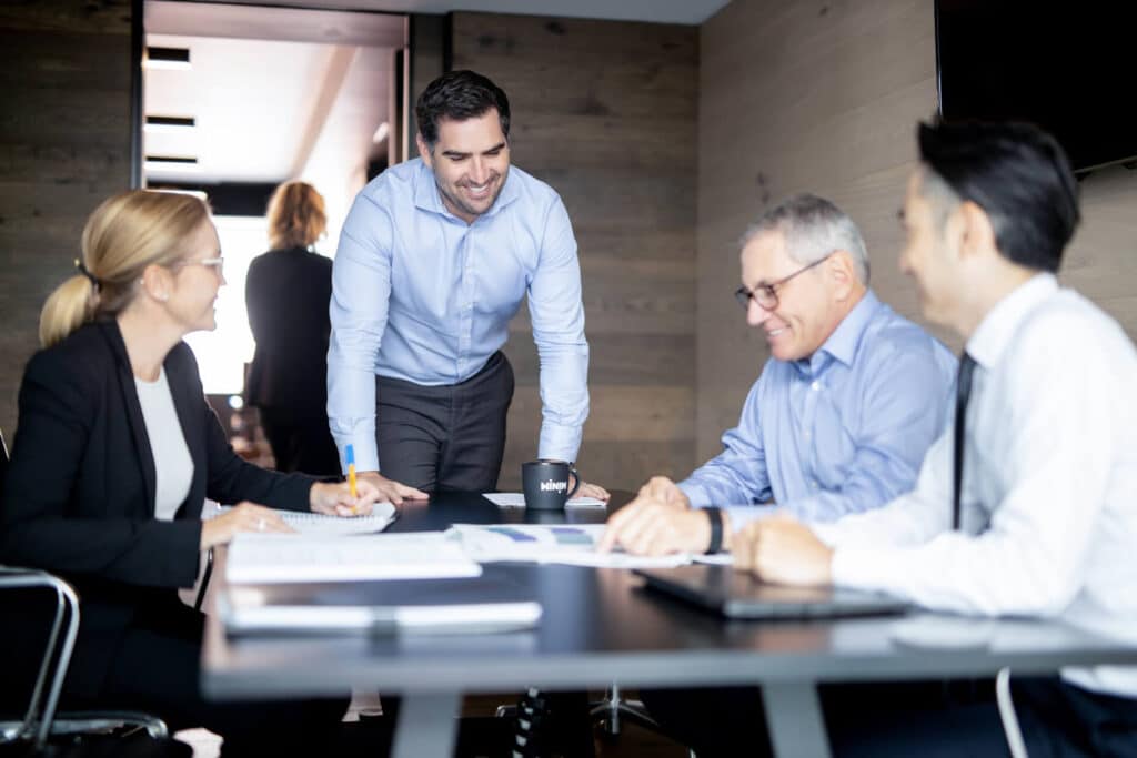 workplace photography with man leaning on desk smiling