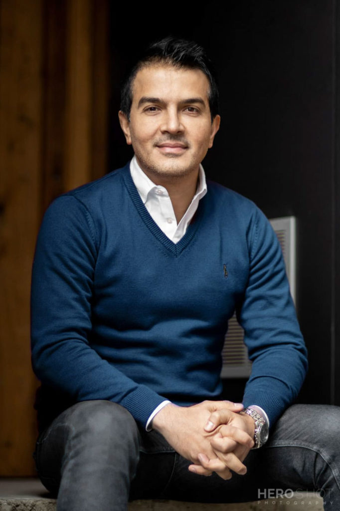 Male seated headshot blue jumper