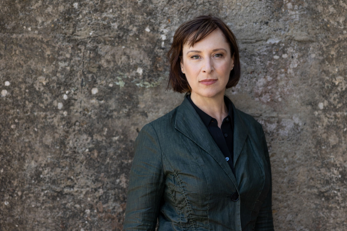 creative headshot female standing by wall