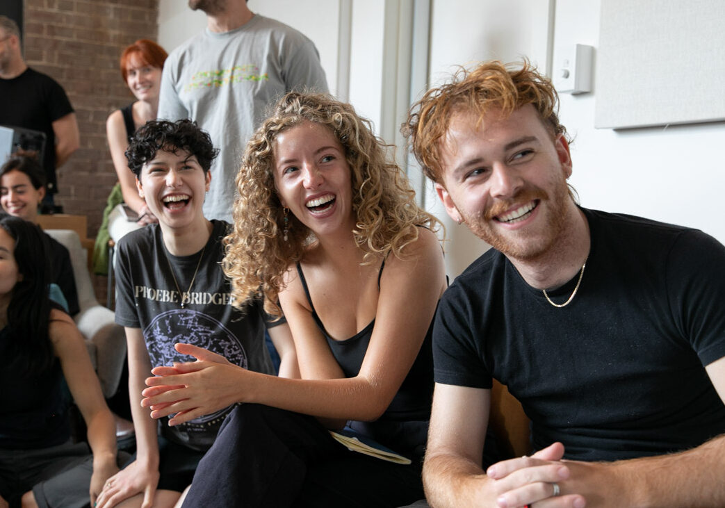 Three young people laughing at an event