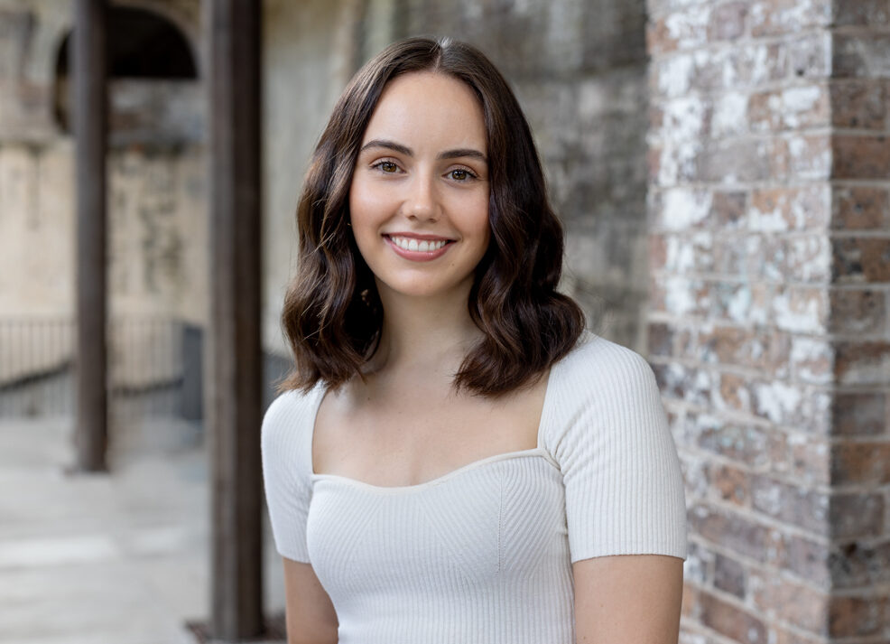 young female standing in a white top