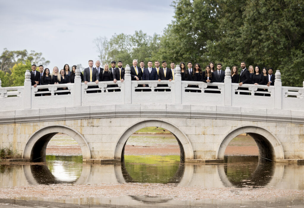 large team of real estate agents standing on a bridge