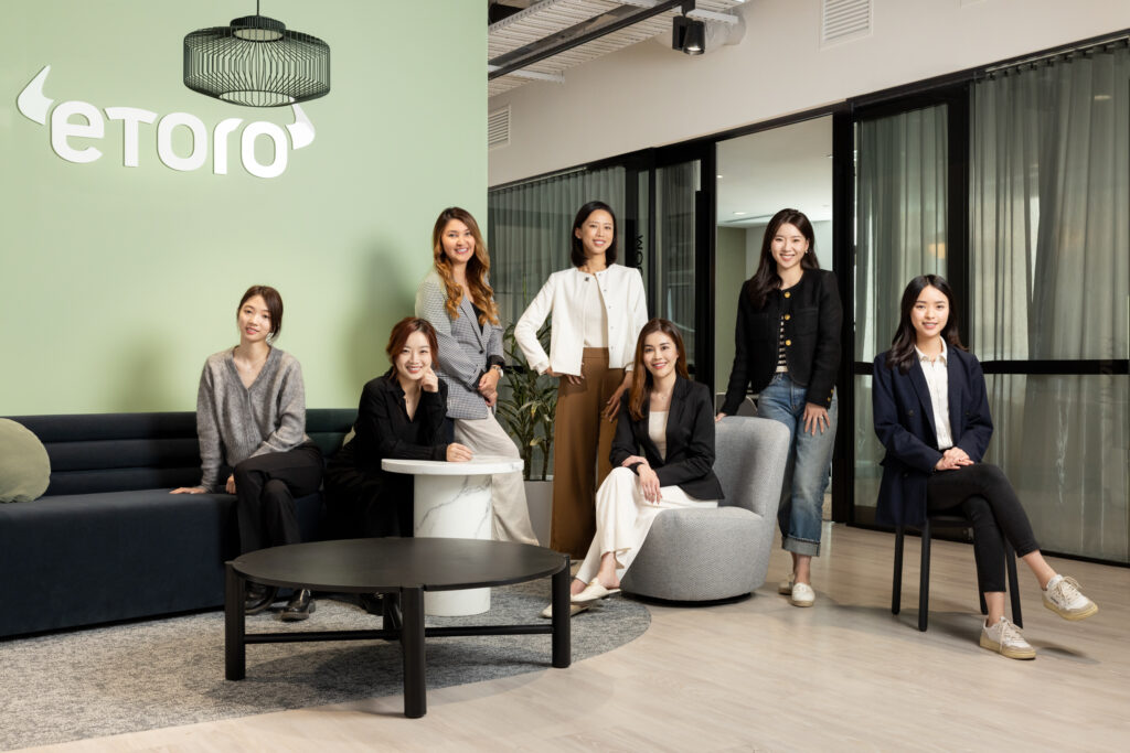 team portrait of 6 females casually sitting around a sofa