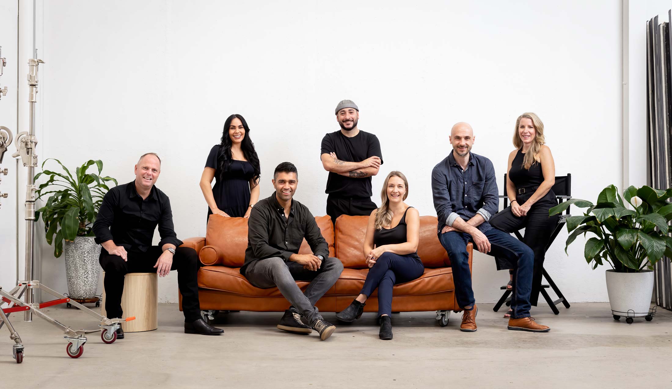 Team Portrait of photographers sitting around a tan coloured couch